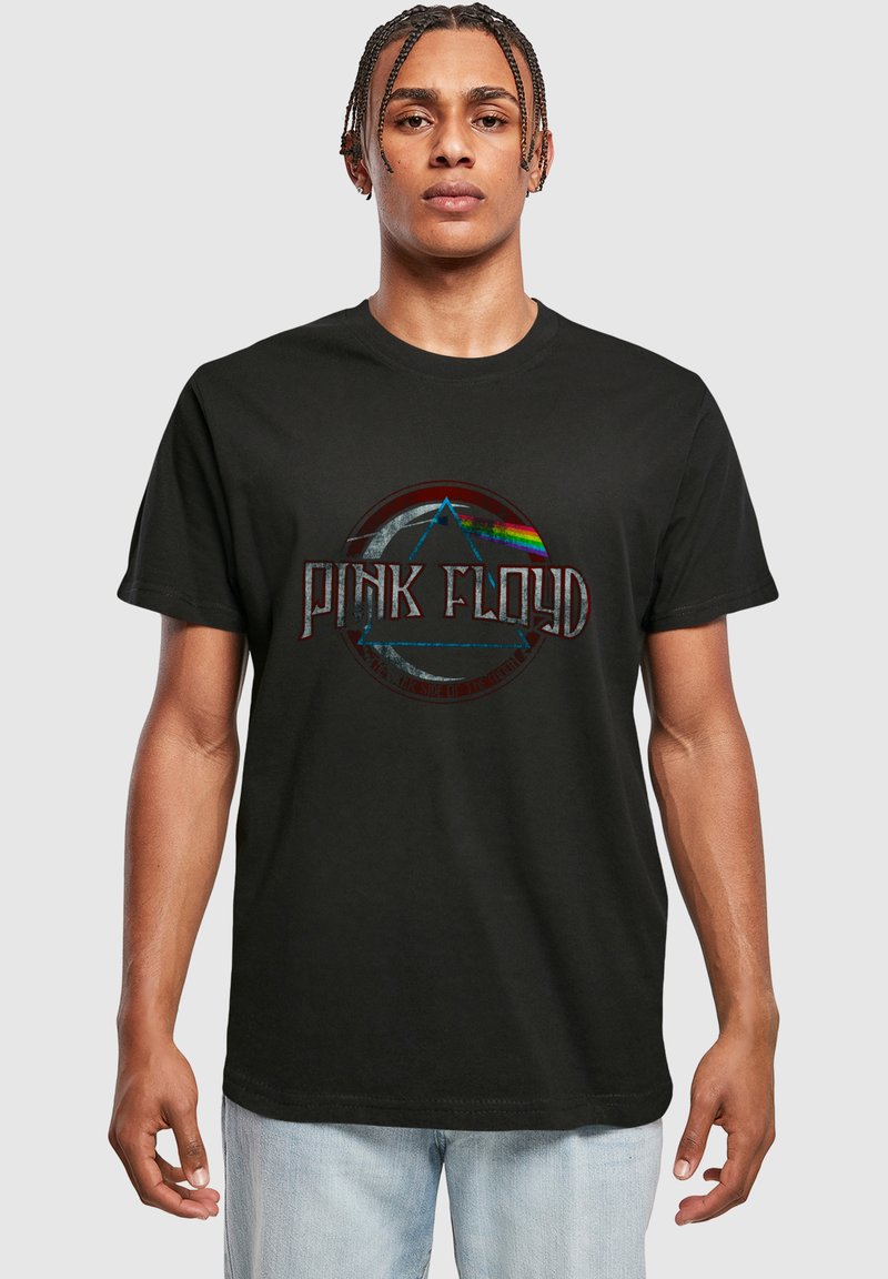 Sort bomulds t-shirt med et grafisk design, der viser teksten "PINK FLOYD" og geometriske former, inklusive en trekant med regnbuefarvede striber.