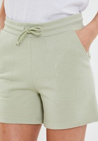 Lichtgroene, hoog getailleerde shorts van zacht materiaal, met een verstelbare tailleband, zijzakken en gladde naden.