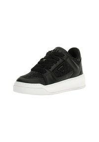 Sneaker nera low-top con pannello laterale testurizzato, suola spessa bianca e lacci neri, inclinata leggermente a destra su uno sfondo bianco.