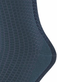 Zwei Paar Socken in Dunkelgrün und Marineblau, mit einem strukturierten Rautenmuster, glatter Oberfläche und verstärkten Nähten entlang der Kanten.