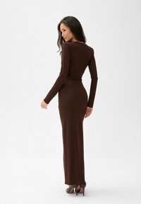 Brą dress z długim rękawem w kolorze brązowym, wykonany z gładkiego, elastycznego materiału, z dopasowanym krojem i okrągłym dekoltem.