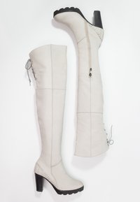 Szare kozaki sięgające do kolan, wykonane z gładkiego materiału, wyposażone w boczny zamek błyskawiczny, teksturowany akcent na pięcie oraz masywną czarną podeszwę.