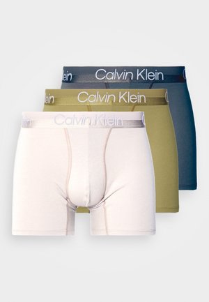 Három pár boxer: világos rózsaszín, olíva és sötétkék színben. Mindegyiken Calvin Klein logós derékpánt és testhezálló kialakítás található, puha tapintással.