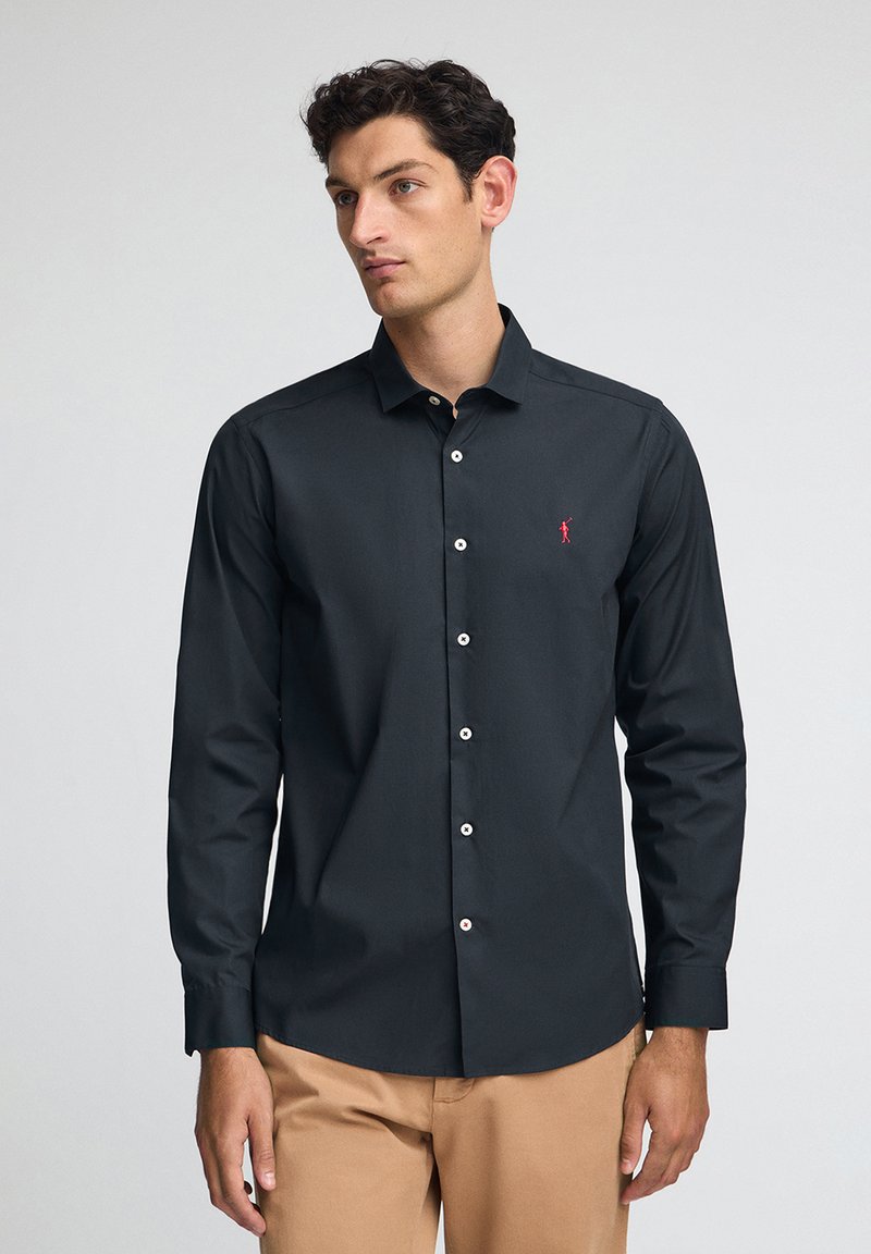 Maglietta a maniche lunghe nera con un piccolo logo rosso sul lato sinistro del petto, colletto button-down e bottoni bianchi. Tessuto liscio, design aderente.