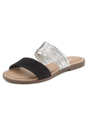 Zwarte suède slipper met een brede band en een zilvermetallic spiraalaccent. Voorzien van een gevoerde inlegzool en een platte, bruine buitenzool.