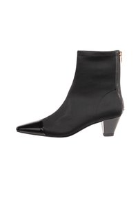 Bottine noire en tissu avec un bout pointu et un capuchon en vernis noir brillant. Dispose d'une fermeture éclair dorée à l'arrière et d'un talon bas.