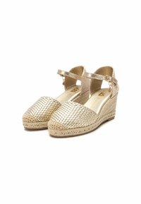 Zapatos tipo espadrilles con cuña, con una parte superior de metal tejido en color dorado, suela de yute trenzado en color beige y correas ajustables al tobillo. Forro interior suave.