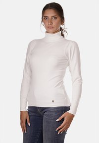 Maglione bianco a collo alto con maniche lunghe, polsini e orlo a coste, con un accento logo dorato vicino alla vita. Texture liscia e morbida.