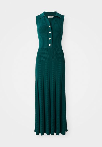 Abito maxi senza maniche di colore verde scuro, con colletto, quattro botttoni frontali e motivi a treccia verticali sulla gonna e sul corpetto.