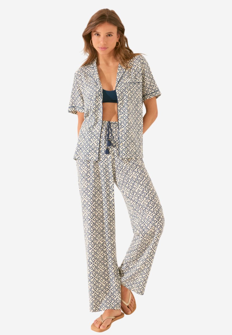 Navy en witte gestreepte pyjamセット met een kortoe mouw shirt en losse broek, gemaakt van lichtgewicht stof, met een trekkoord taille.
