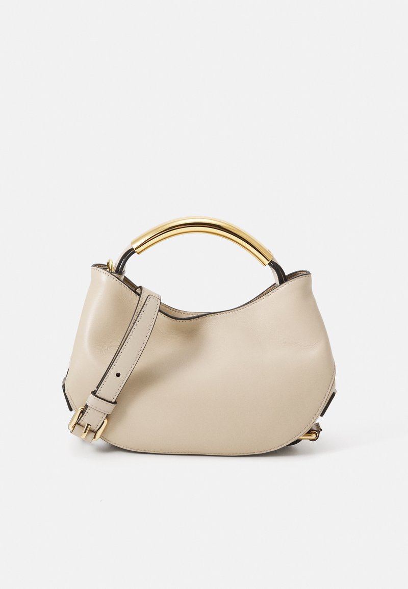 Beżowa skórzana torebka z złotym metalowym uchwytem, odpinanym paskiem i miękkim, zaokrąglonym kształtem. Gładka tekstura z czarnymi akcentami.