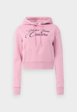 Pink cropped hoodie featuring a drawstring hood and the text "Versace Jeans Couture" in black glitter across the front. Soft fabric, ribbed hem.