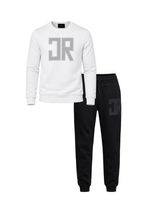 Felpa bianca a maniche lunghe con grande logo "JR" grigio specchiato abbinata a pantaloni jogger neri con logo "JR" nero abbinato sulla coscia.