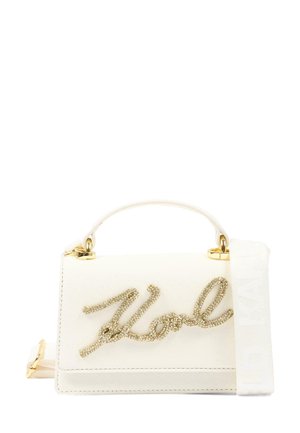 Biała torebka z napisem "Karl" w kolorze złotym, krótką rączką i szerokim materiałowym paskiem na ramię z wytłoczonym napisem "Karl Lagerfeld".