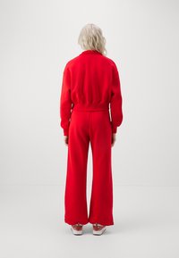 Nike Sportswear SPORTSWEAR PHOENIX FLEECE - Tracksuit bottoms - university red