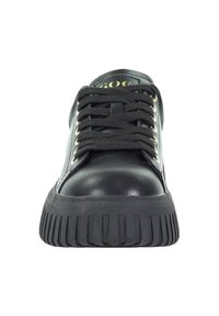 Czarne sneakersy o grubej, rowkowanej podeszwie, czarnych sznurówkach i złotych oczkach, widziane z przodu.