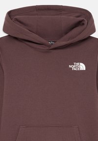 Sweatshirt capuz bordeaux com um bolso frontal, apresentando um logótipo branco no lado esquerdo do peito. Material de algodão suave com uma textura lisa.