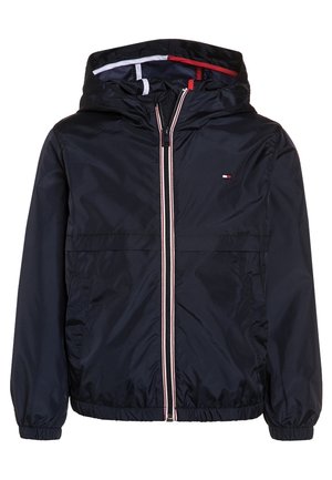 Mørkeblå hættejakke med lynlås foran med hvide og røde striber, elastiske ærmegab og et lille flaglogo på brystet.