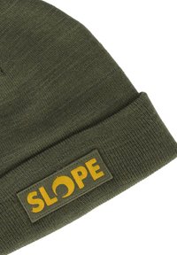 Olivgrüne Mütze aus Strickstoff mit umgeschlagenem Bund und einem rechteckigen gelben Aufnäher, auf dem das Wort "SLOPE" steht.
