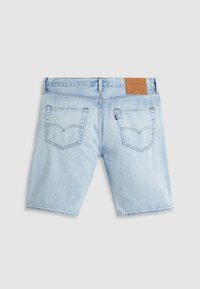 Shorts din denim de culoare albastru deschis, cu o croială lejeră, cinci buzunare și o etichetă din piele marron la talie. Margine brută cu detalii de cusătură vizibile.