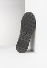 Sola di scarpa grigia con gomma testurizzata, scanalature diagonali per grip e dettagli del logo in rilievo. Prodotta in Italia, taglia 42.