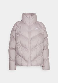 Vadderad jacka i ljust lavendel med hög krage, dragkedja, chevronmönster och elastiska ärmslut. Har en subtil logotyp på bröstet.