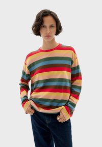 Langsleeve shirt met meerkleurige strepen in rood, groen, geel en blauw. Gemaakt van zachte stof met een ronde halslijn en een comfortabele pasvorm.