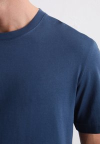 Marineblauw T-shirt met korte mouwen en een ronde hals, gemaakt van een gladde, lichte stof, met een egale textuur en subtiele stiksels.