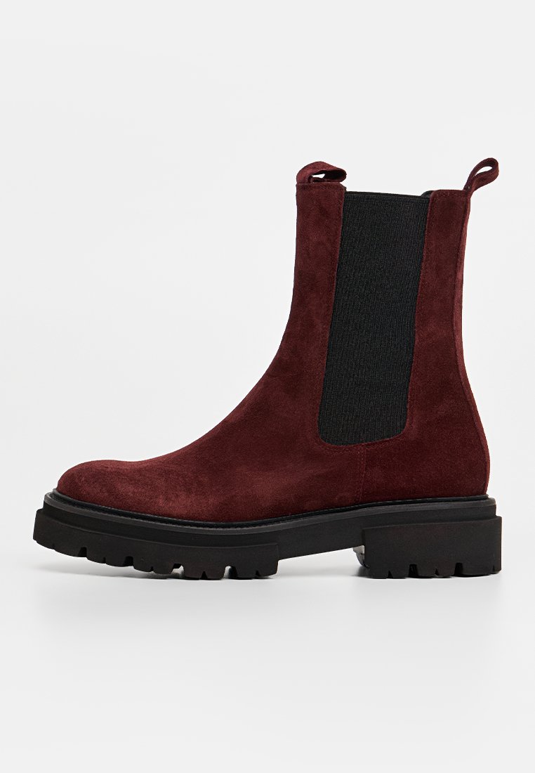 Burgunderfarbene Wildleder-Stiefelette mit elastischen Seitenpaneelen, robuster schwarzer Sohle und Ziehlasche hinten für einfaches An- und Ausziehen.