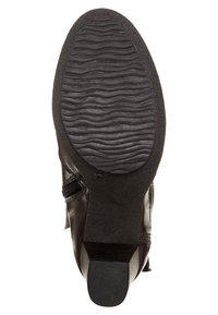 Svart läderankelboot med en texturerad gummisula, sidodragkedja och rundad tå. Har ribbor för grepp på sulan.