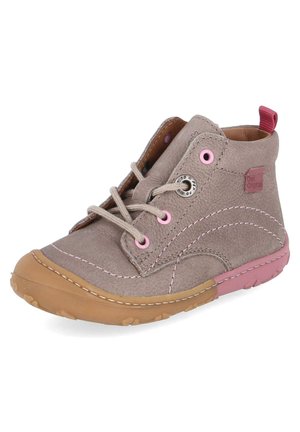Beiger Wildleder-Kinderstiefel mit rosa Ösen, beigen Schnürsenkeln, genähter Sohle und rosa Fersenlasche auf weißem Hintergrund.