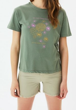 Olive green cotton t-shirt with short sleeves, featuring a printed design in gold, pink, and white. Casual fit with a rounded neckline.