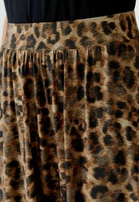 Plissé rok met een luipaardprint in bruin- en zwarttonen. Gemaakt van lichte stof met een tailleband voor een comfortabele pasvorm.