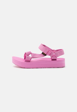 Sandalo rosa con cinturino regolabile e suola spessa, con chiusure in velcro sulle fascette di punta, caviglia e tallone.
