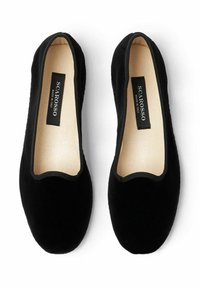 Zwarte fluwelen instappers met elastische randen, ronde neus en een gladde binnenvoering. Gemarkeerd met het label "SCAROSSO MADE IN ITALY".