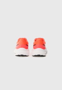 Baskets de sport avec une tige corail vif, une semelle intermédiaire blanche, une semelle extérieure noire et des accents à motifs sur le talon et la tige pour une meilleure respirabilité.