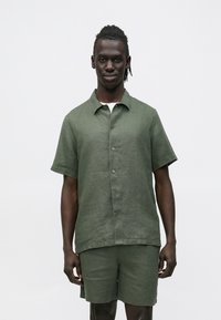 Korte mouw, overhemd met kraag en korte broek set in olijfgroen linnen stof, voorzien van knopen en een ontspannen pasvorm met een gladde textuur.
