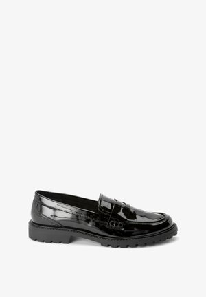 Mocassini in vernice nera con una suola piatta bassa, caratterizzati da una fascia testurizzata sulla parte superiore e da cuciture dettagliate lungo i bordi.