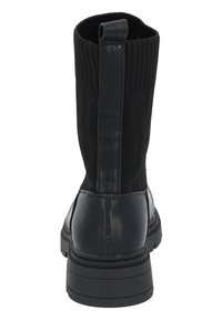 Czarne botki za kostkę z dzianinową cholewką i gładką skórzaną dolną częścią, wyposażone w solidną gumową podeszwę oraz uchwyt ułatwiający zakładanie.