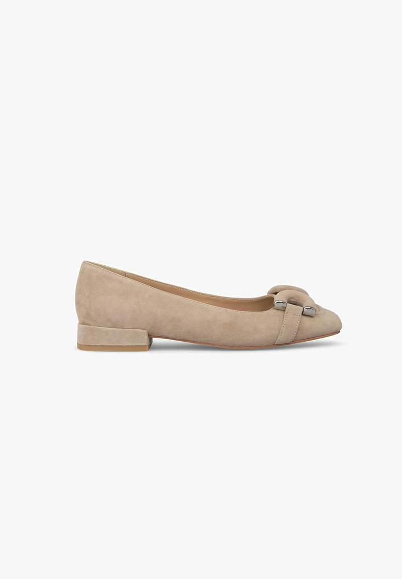 Bailarinas de ante beige con un bajo tacón tipo block, punta afilada y un lazo decorativo con acentos plateados en la parte superior. Textura suave.