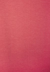 Kokvilnas audums dzīvīgā korallkrāsā, ar gludu tekstūru un mīkstu, vienmērīgu adījuma rakstu visā audumā.