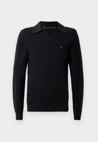 Sort pullover sweater med et struktureret strikdesign, der har V-hals og en kontrastfarvet krave. Lille logo detalje på brystet.