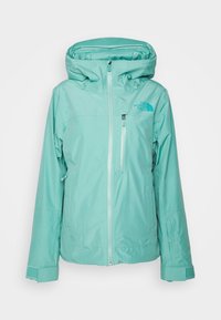 Helle teal wasserfeste Jacke mit Reißverschluss vorne, verstellbarem Kapuze und Bündchen. Mit einem Logo auf der Brust und einer Reißverschlusstasche an der Seite.