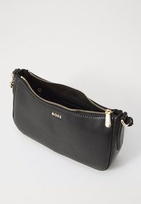 Borsetta a tracolla in pelle nera con zip e accessori in tono oro. Presenta una chiusura con zip e un logo impresso sul fronte. Design compatto e elegante.