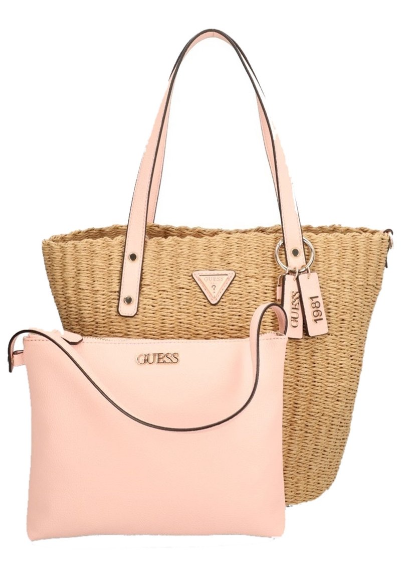 Sac fourre-tout en paille tissée avec poignées et étiquettes en cuir rose, accompagné d'une pochette zippée en cuir rose, tous deux arborant la marque Guess.