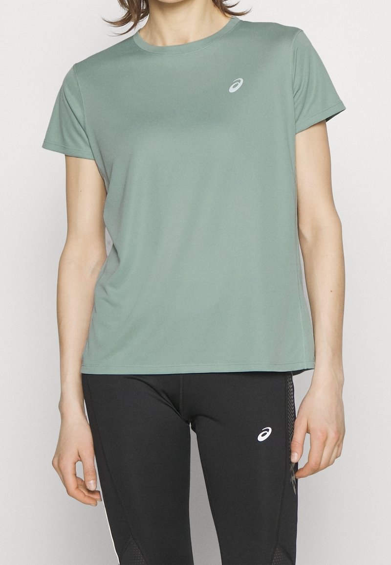 Sportovní tričko s krátkým rukávem ve světle zelené barvě, vyrobené z hladké látky. Má malý logo na hrudi a klasický kulatý výstřih.