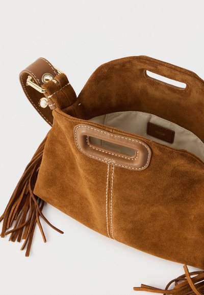 Καφέ σουέντ τσάντα χειρός με χειρολαβές με άνοιγμα διακοσμημένες με δερμάτινη επένδυση, διακοσμητικό κρόσσι στα πλάγια και μπεζ ύφασμα στο εσωτερικό.