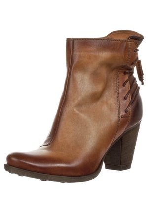 Bottine en cuir marron avec talon bloc empilé, bout arrondi et détail à lacets à l'arrière.