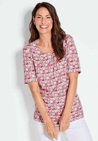 Kurzärmliges Oberteil mit einem pinken Blumenmuster und rundem Ausschnitt. Weicher Stoff mit einer figurbetonten Silhouette. Mit subtilen Details akzentuiert.