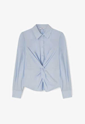 Hellblaues langärmliges Hemd mit Knopfleiste, Kragen und einem gedrehten Knoten-Detail in der vorderen Mitte.